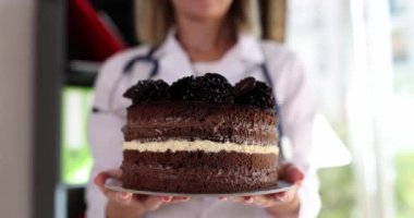 Chocolate cake in the hands of a doctor, close-up, slowmotion. Successful operation, holiday in the clinic