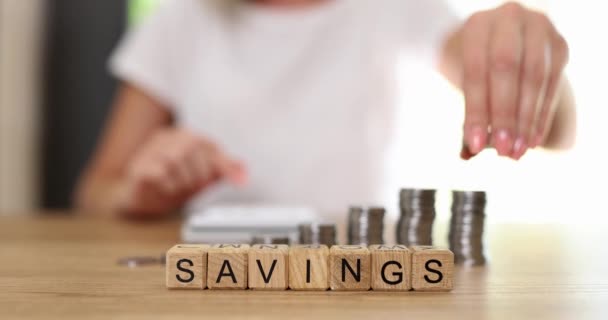 Savings Inscription Wooden Cubes Table Close Slowmotion Woman Folds Coins — Vídeos de Stock