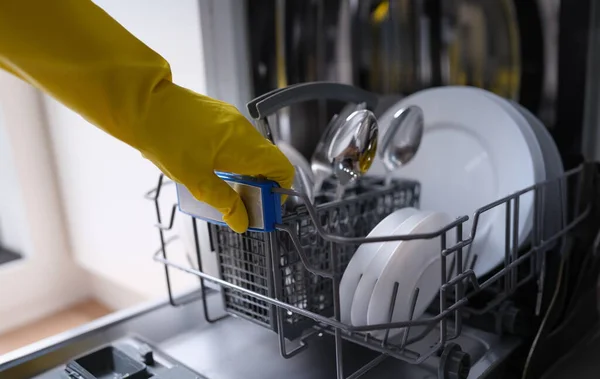 Open dishwasher with clean dishes and housewife. Hygiene and housework concept