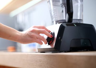 Kadın sağlıklı bir kokteyl hazırlamak için sabit blender kullanıyor. Şef blender ya da çoklu kombinasyon konseptini açar