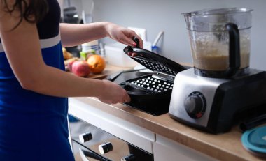 Kadın, Viyana ve Belçika gözlemeleri için elektrikli waffle makinesi açıyor. Örnek mutfak aleti modeli