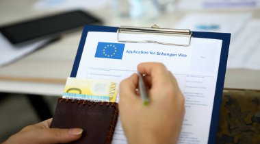 Erkek el pasaportlu gümüş kalem tutun. Schengen apllikasyon formu kavramının doldurulması