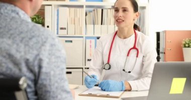 Kadın doktor resepsiyondaki erkek hastayla iletişim kuruyor. Tıbbi bakım konsepti