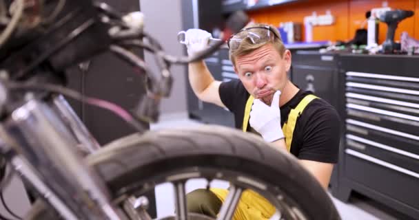 Überraschter Mann Reparaturarbeiter Zerkratzt Kopf Mit Schraubenschlüssel Vor Kaputtem Motorrad — Stockvideo