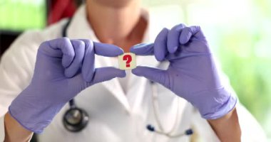 Doktor kardiyolog klinikte soru işareti tutuyor. Tıbbi sorular ve cevaplar kavramı ve uzaktan tıbbi danışmanlık