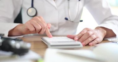 Tıbbi uygulamalarda ve hastanede hesap makineli doktor masrafları ve geliri hesaplıyor. Sağlık sigortası maliyeti