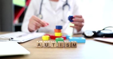 Doktor renkli küpler ve yazıt otizmi yakın plan. Çocuklarda otizm belirtileri ve yetişkinlerde semptomlar.