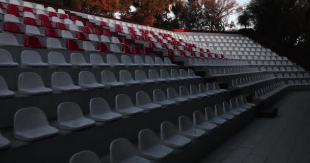 竞技场或礼堂的看台上的空座位 没有观众的体育场里一排排红白相间的座位 — 图库视频影像