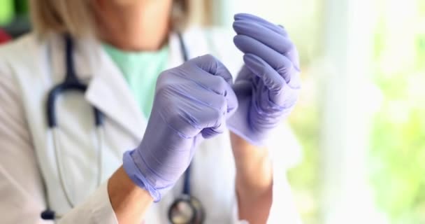 医師はクリニックで使い捨て医療用手袋を削除します 女性医師は作業日後に保護手袋を削除します — ストック動画