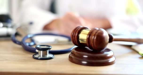白いコートの医療従事者は裁判官のために医学診断と木製の砂利を書きます 医療訴訟の概念 — ストック動画