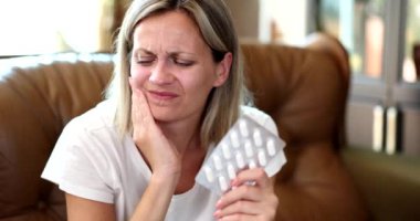 Yanağa dokunan zavallı kadının portresi, diş bölgesinde rahatsızlık ve acı hissediyor. Diş ağrısı için ağrı kesici.