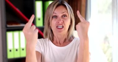 Beautiful angry aggressive woman showing middle finger, making a fuck you bad expression. Woman provocative and rude attitude and screaming excited