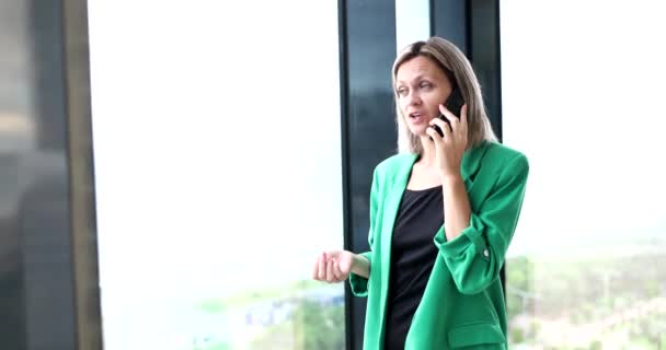 Uśmiechnięta Bizneswoman Rozmawiająca Przez Telefon Nowoczesnym Szklanym Biurze Zdalne Negocjacje — Wideo stockowe