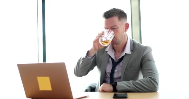 由于经济条件差 工作压力大 商人手里拿着威士忌 正在看笔记本电脑 工作场所的酗酒 — 图库视频影像