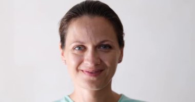Kameraya bakan kendinden emin, genç, yetişkin bir kadın. Beyaz dişleri olan mutlu bir kadın. Güzel bir yüz. Portre için poz veriyor.