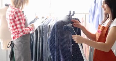 İki kuru temizlemeci kıyafetlerle çalışıyor. Kumaş temizleme ve kurutma kavramı