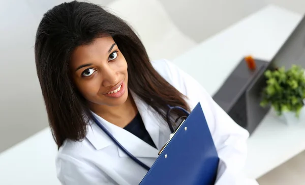 Beautiful black smiling female doctor at workplace portrait. Physical and disease prevention patient aid exam visit ward round, prescribe remedy healthy lifestyle consultant profession concept