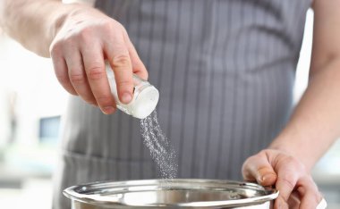 Şef Giyen Önlük Çanak Beyaz Deniz Tuzu Ekleme. Erkek Eller Tencereye Baharat Koyuyor. Evde Mutfakta Yemek Pişiren Adam. Organik Hazırlanıyor. Yemek Tarifi. Holding Shaker Yatay Fotoğrafçılık