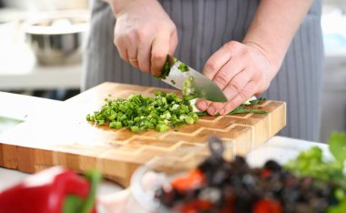 Şef Eller Tutan Bıçak Kesme Yeşil Soğan. Man Mutfakta Ahşap Tahta üzerinde Keskin Bıçak ile Soğan Doğrama. Diyet Pişirme için Taze Yeşiller. Sağlıklı Ev Mutfak Yatay Fotoğrafçılık
