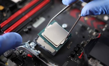 Cımbız tutan ve ayrıntıları bağlayan eldiven takan kişiye yakın çekim. Laptop teknisyeni ana karta yükleniyor. Teknoloji ve mühendislik kavramı