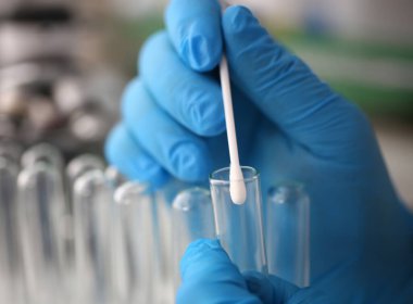 Adli tıp uzmanı, laboratuvar geçmişine karşı adli soruşturma yürütüyor. Elinde DNA örneği ve bir test tüpü ile pamuklu bez tutar. Tets babalık kavramı.