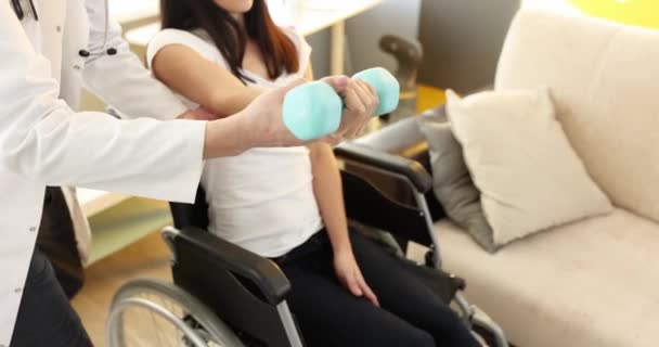 Rehabilitációs Orvos Segít Kerekesszékes Nőnek Súlyzókkal Gyakorolni Fizikai Aktivitás Helyreállítása — Stock videók