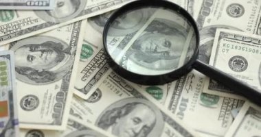 Bir sürü kağıt para banknotunun üzerinde büyüteç var. 4K 'lık filmi yavaş çekimde çekiyoruz. Kalpazanlık konsepti