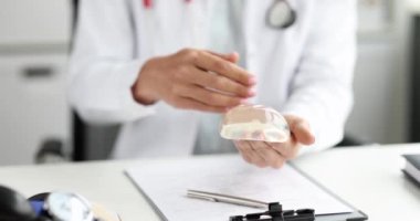 Plastik cerrah silikon göğüs implantı gösteriyor. Yakın çekim 4K film ağır çekim. Estetik tıp göğüs büyütme konsepti