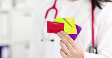 Doktor elinde bir sürü renkli prezervatif tutuyordu. 4K 'lık filmi yavaş çekimde çekiyordu. Hamilelik planlama kavramı