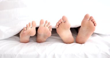İlişki sorunları. Evli çift yatakta birbirini görmezden geliyor. Yatakta kadın ve erkek bacakları
