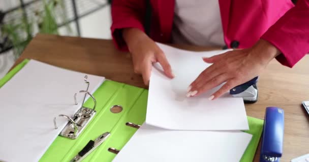 穴パンチで文書上の紙で穴を作る女性の手の閉鎖 ビジネス文書を扱う秘書 — ストック動画
