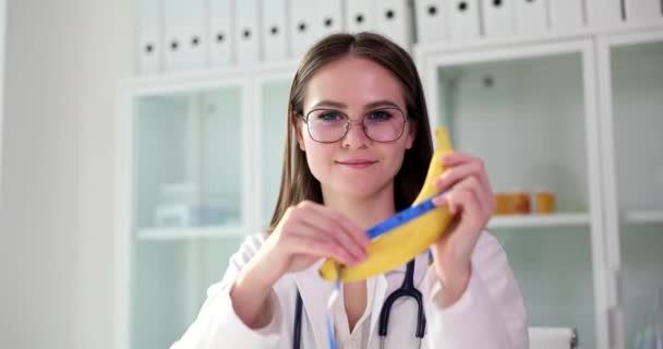 医師の女性泌尿器科医は バナナを保持し 手でテープを測定します 勃起不全と弱い勃起 — ストック動画