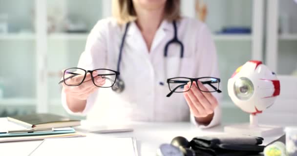 眼科医は眼鏡の2つのペアの選択を提供しています ビジョンチェックとヘルスケアのコンセプト — ストック動画