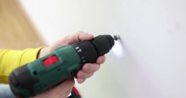 Daire duvarında kablosuz matkapla vida delmek. Daire yenileme aracı