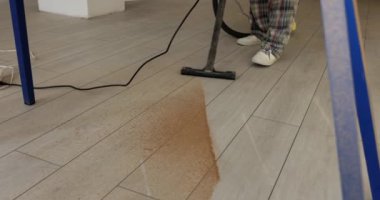Profesyonel elektrik süpürgesi, yerden talaş ve toz topluyor. Tamir sonrası çöp toplama