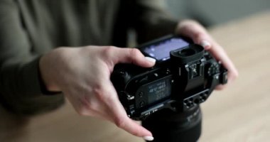 Kadın fotoğrafçı siyah profesyonel kamerada fotoğraflara bakıyor. Yakın çekim 4K film ağır çekim. Hobi fotoğrafçılık konsepti