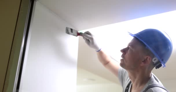 Männliche Bauarbeiter Malen Wand Weiß Mit Pinsel Film Zeitlupe Abschlussarbeiten — Stockvideo