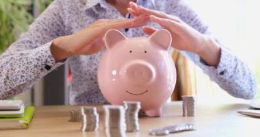 Insurance agent woman holds hands on piggy bank. Protection and security of financial and banking savings concept