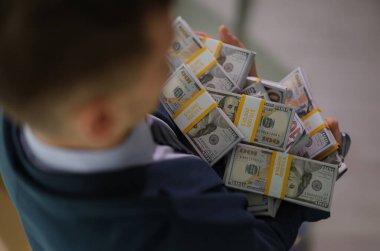 Bankacı elinde bir sürü paket ve yakın plan para tutuyor. Piyango kazancı ve iş başarısı konsepti