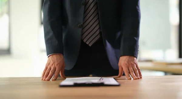 Manager standing at table with documents at business conference closeup. Paper work contract concept