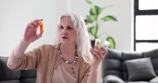 Äldre Kvinna Tittar Medicin Burkar Hemma Film Slow Motion Behandling — Stockvideo