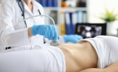 Sonograf teknisyeni, hamile bir kadının uterusa bilgisayar ekranında baktığını belirlemek için ultrason sondası tutuyor. Rahmin ultrasonu ve dişi üreme sistemi konsepti