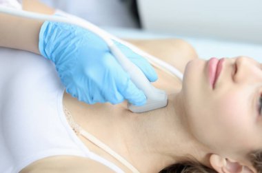 Tıbbi klinikteki kadının tiroit bezini tarıyorum. Yakın plan. Kadın konseptinde endokrin bezinin yerini yansıtan araştırma