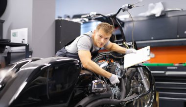 Erkek tamirci, servis merkezinde modern motosiklet teşhisi koydu. Araç bakım ve ulaşım sigortası kavramı