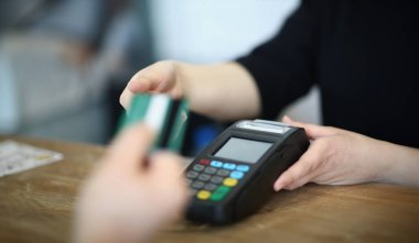 Satıcı kredi kartı almak için alıcı teklif ediyor. Mallar için ödeme terminali kavramı ile ödeme