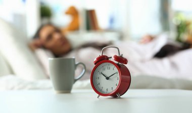 Saat 10 'da kırmızı alarm ve uyuyan kadın. Huzurlu uyku ve geç uyanma konsepti