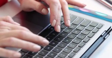 Dizüstü bilgisayarda yazı yazan kadın elleri 4K 'lık filmi yavaş çekimde kapatıyor. Çevrimiçi iş kavramı