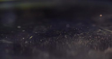 Sarı damla petrolün yüzeyine düşüyor. 4K yakın çekim filmi. Aroma yağı kavramı