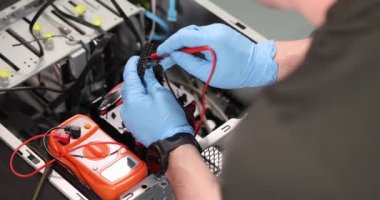 Lastik eldivenler ustası atölyedeki test ediciyle bilgisayar tekniğini kontrol ediyor. 4K yavaş çekim. Bozuk bilgisayar donanımı konsepti teşhisi