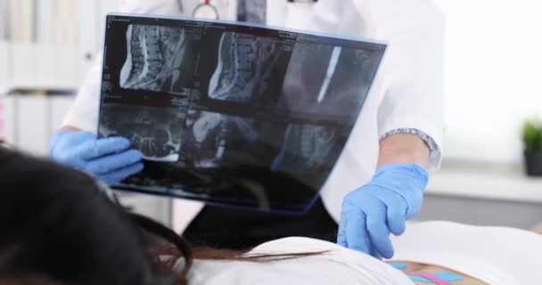Osteopaat Palpating Spinale Processen Van Patiënt Met Kinesio Tapes Kijken — Stockvideo